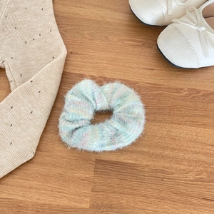 Sweet mint green mohair knit hair scrunchie with soft fuzzy texture on wooden background