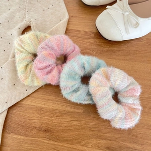 Rainbow mohair scrunchies set in macaron colors on a rustic wooden background
