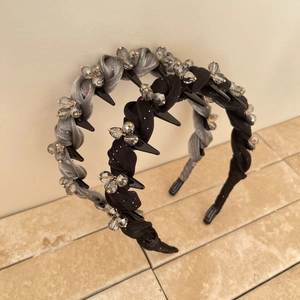 Detailed view of silver and black woven headbands with crystal beads and spikes