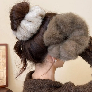 Close-up of oversized plush faux mink fur scrunchies in cream and brown colors