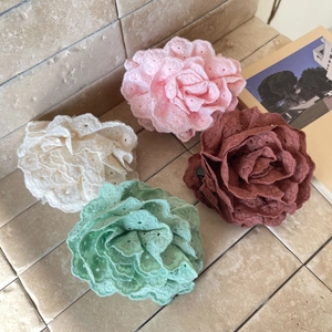 Detail of embroidered fabric rose hair claws in pink, cream, green and brown colors