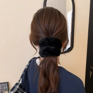 Detail view of a soft black faux fur scrunchie on a ponytail for autumn winter style