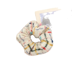 Elegant plaid tweed scrunchie in cream with multicolored patterns and textured fabric