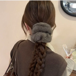Plush faux fur oversized hair scrunchie in grey worn on a braided hairstyle for autumn