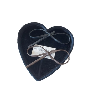 Minimalist leather bow hair clips set in black and dark brown on a decorative tray