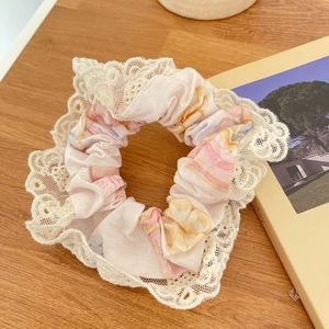 Chouchou fleuri avec bordure en dentelle sur fond de bois vintage pour femmes