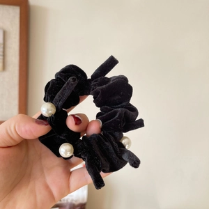 Elegant black velvet bow scrunchie with white pearl accents for a gentle vintage hair look