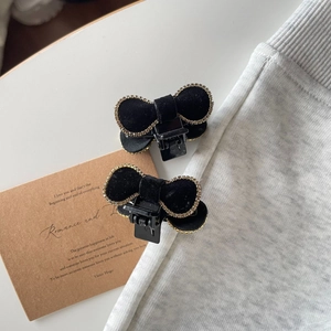 Elegant pair of black velvet bow hair claws with rhinestone edges on neutral background
