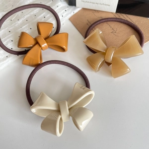 Three elegant bow hair ties in amber and cream resin with elastic bands for women