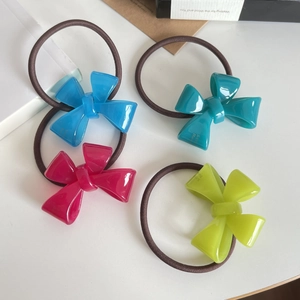 Set of four elastic hair ties with colorful acrylic bow charms in bright candy colors