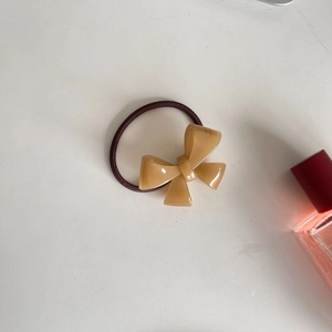 Detailed macro view of the brown elastic hair tie with a resin bow on a white desk