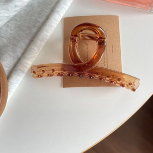 Elegant amber cloud-shaped shark hair claw clip for women on a cozy minimalist desk