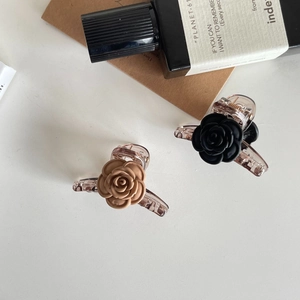 Dettaglio ravvicinato di mollette per capelli in acrilico marrone con rose 3D opache