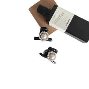 Elegant black hair claw clips with baroque pearls and gold trim on white background