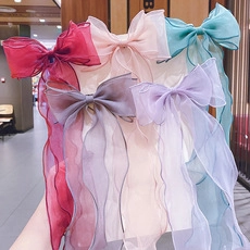 Detail of colorful oversized chiffon bow hair clips with long wavy flowing streamers