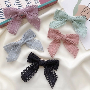 Five-piece set of lace bow hair clips in pastel colors over a minimalist background