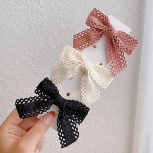 Set of three lace bow hair clips in pink, white, and black with delicate woven details