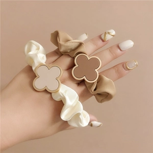 Two-piece set of elegant satin scrunchies with clover charm in beige and cream