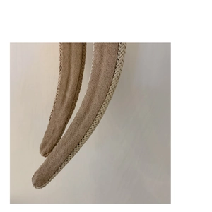 Dettaglio della trama intrecciata e del camoscio marrone sulla fascia per capelli larga