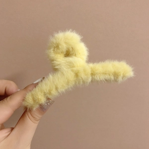 Vue détaillée de la pince à cheveux en peluche jaune vif en fausse fourrure douce