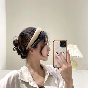 Détail du serre-tête en velours beige et d'une pince à cheveux en métal doré tissé