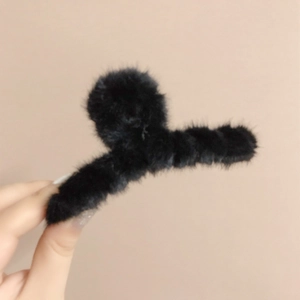 Gros plan détaillé d'une pince à cheveux en fausse fourrure noire à texture douce