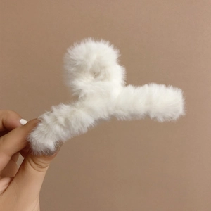 Détail de la texture en fausse fourrure blanche d'une pince à cheveux d'hiver douce