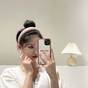 Détail d'un serre-tête en éponge rose épais avec des boucles d'oreilles blanches