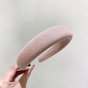 Détail d'un serre-tête large en éponge rose clair avec texture de tissu côtelé fin