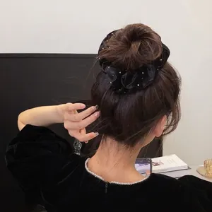Chouchou élégant en velours noir à pois dorés, style Hepburn vintage, porté sur le modèle
