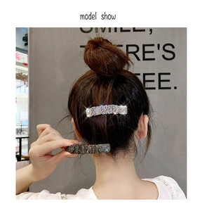 Detailed view of sparkling rhinestone hair clips worn on an elegant bun hairstyle