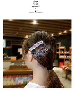 Close-up of sparkling rhinestone hair clips set in silver and grey on a model's hair