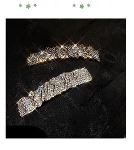 Detailed view of silver hair clip with dense sparkling rhinestones on black fabric