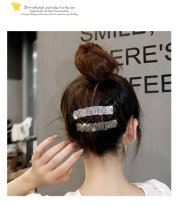 Detail of silver sparkling rhinestone hair clips worn in a stylish bun updo hairstyle