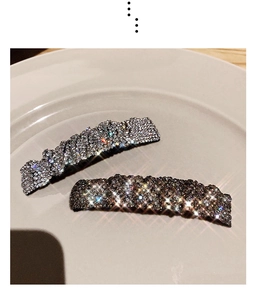 Macro detail of two sparkling rhinestone hair clips in silver and smoky grey finishes