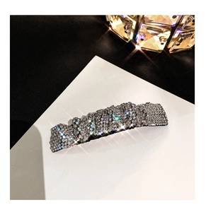 Macro shot of sparkling crystal hair clip with silver rhinestone setting for elegant styling