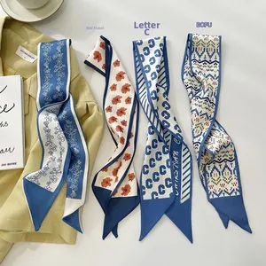 Close-up of four floral and geometric printed silk twilly scarves on a yellow blazer