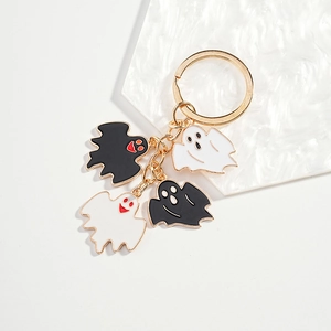 Cute Halloween ghost keychain with four charms in gold finish on white marble base