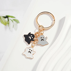 Golden keychain with three cute cartoon ghosts in black, grey and white enamel pendants
