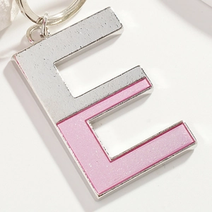 Creative letter E keychain with pink glitter and silver metal on a clean white background