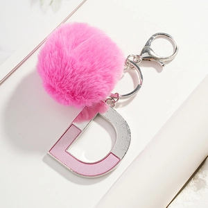 Porte-clés pompon en fausse fourrure rose avec breloque lettre D argentée et fermoir
