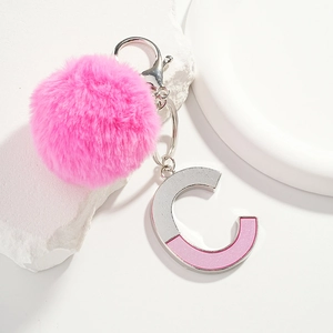 Porte-clés pompon en fourrure rose avec pendentif lettre C argenté sur fond moderne