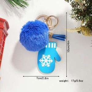 Detailed view of Christmas keychain with blue faux fur pompom and snowflake mitten charm