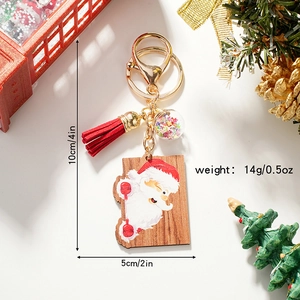 Cute wooden Santa Claus keychain with red tassel and sparkling star charm on white background
