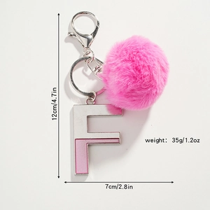 Détail porte-clés pompon rose avec lettre F argentée montrant la mesure de 12cm