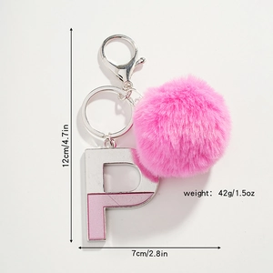 Détail du porte-clés pompon en fourrure rose avec pendentif lettre P en métal argenté