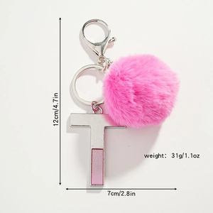 Détail d'un porte-clés pompon rose duveteux avec pendentif lettre T en argent et dimensions