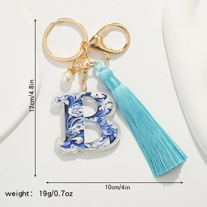 Detailed size view of blue floral porcelain letter B keychain with tassel and gold hardware