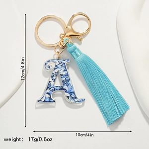 Detailed view of blue and white floral porcelain letter A keychain with silk tassel