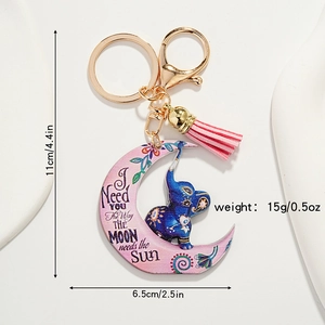 Detail of cute elephant and pink moon keychain with a soft tassel and gold hardware